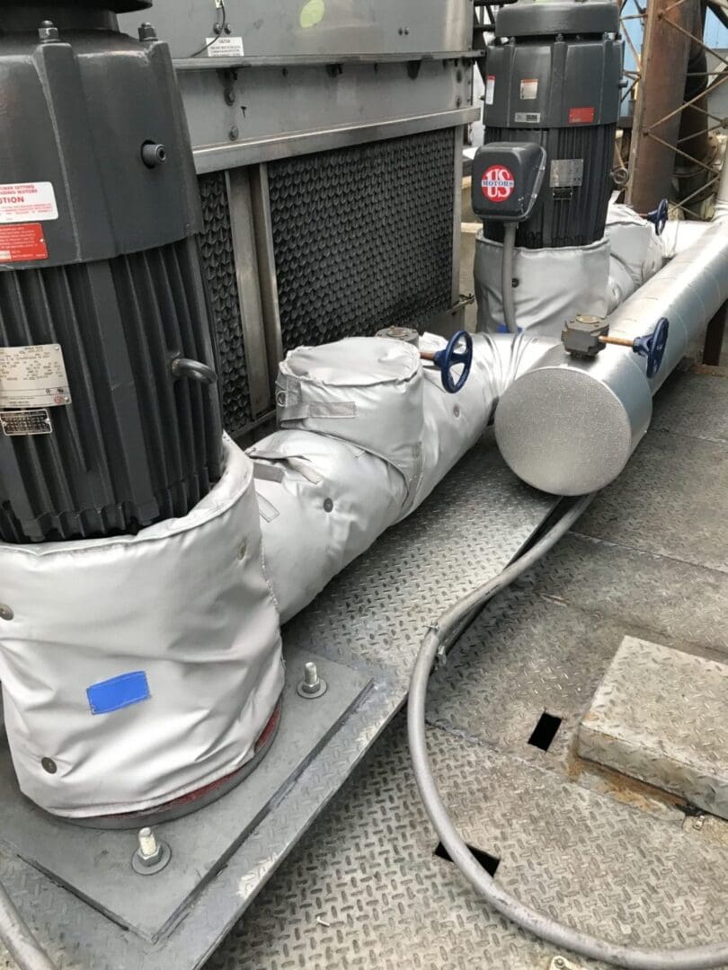 A large air conditioner is covered with tarps.