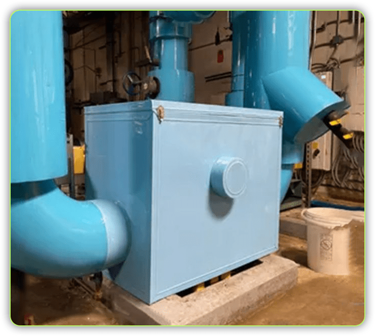 A blue box sitting in front of two pipes.