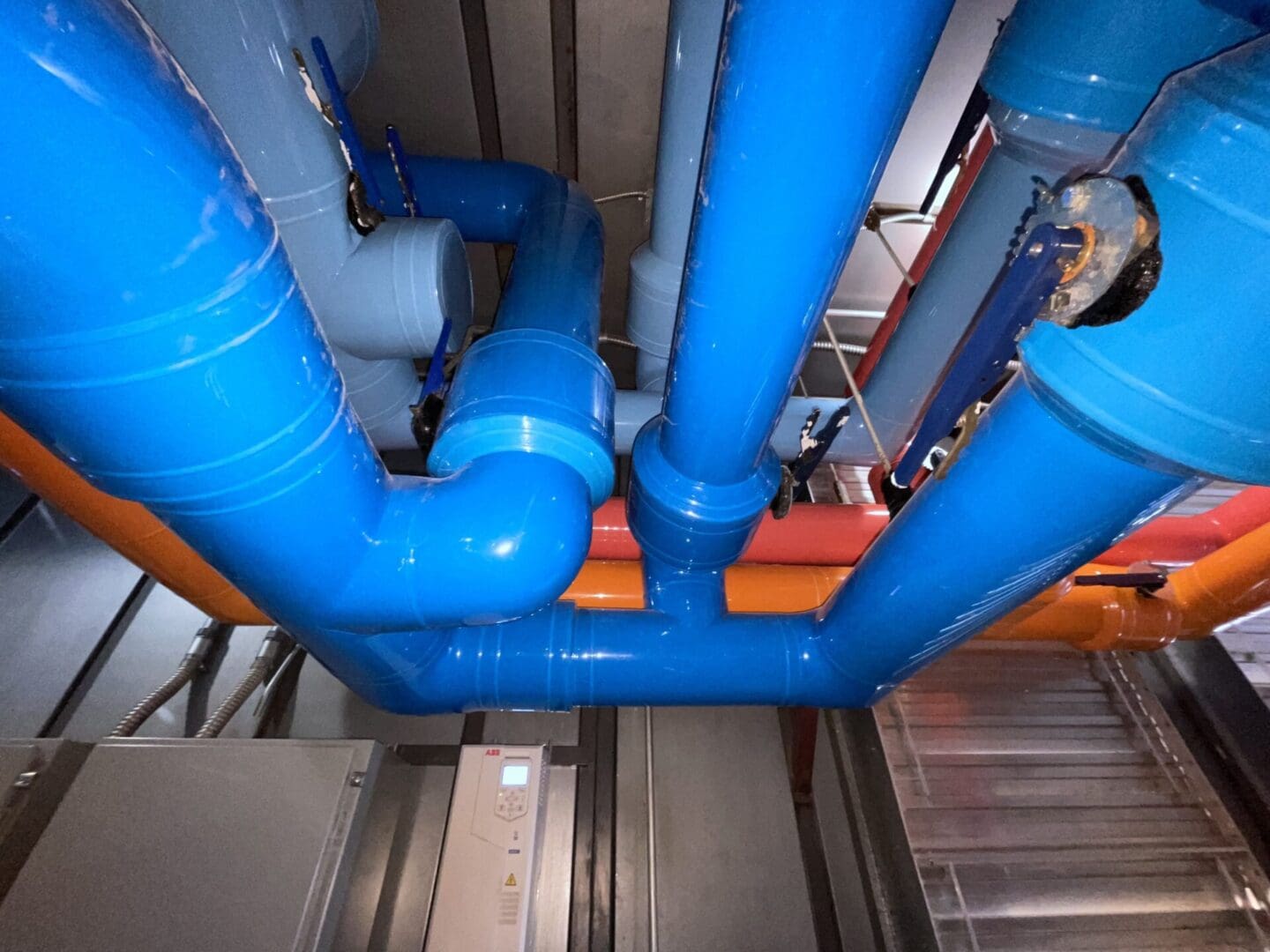 A view of pipes from above in a building.