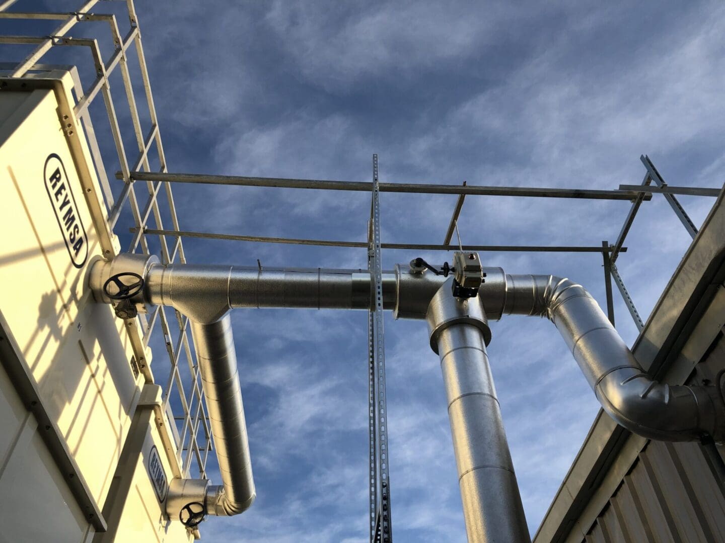 A view of pipes and wires from below.